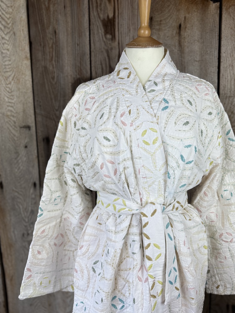 A luxury white dressing gown made using the traditional Indian technique of Cutwork. Additional hand embroidery in pastel shades.