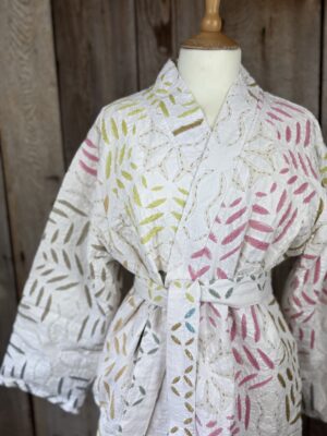 A luxury white dressing gown made using the traditional Indian technique of Cutwork. Additional hand embroidery in pastel shades.