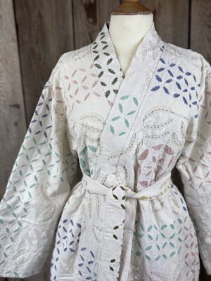 A luxury white dressing gown made using the traditional Indian technique of Cutwork. Additional hand embroidery in pastel shades.