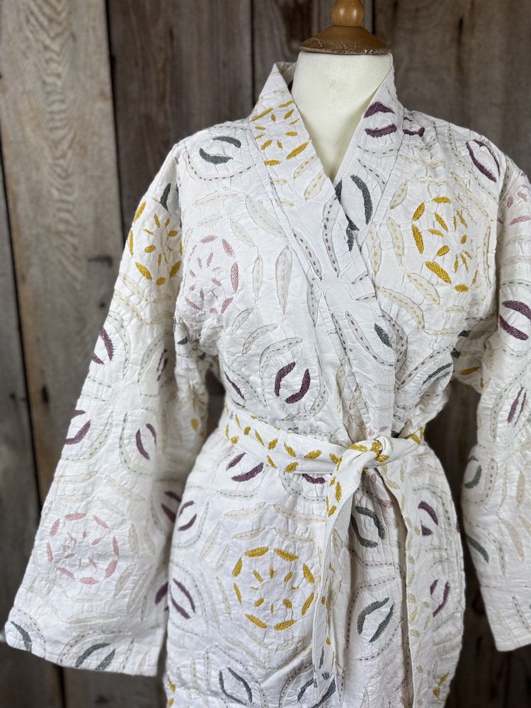 A luxury white dressing gown made using the traditional Indian technique of Cutwork. Additional hand embroidery in pastel shades.
