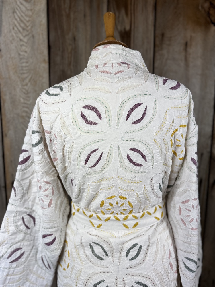 A luxury white dressing gown made using the traditional Indian technique of Cutwork. Additional hand embroidery in pastel shades.