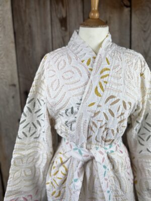 A luxury white dressing gown made using the traditional Indian technique of Cutwork. Additional hand embroidery in pastel shades.