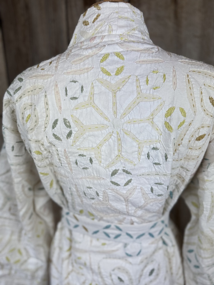 A luxury white dressing gown made using the traditional Indian technique of Cutwork. Additional hand embroidery in pastel shades.