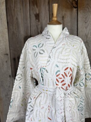 A luxury white dressing gown made using the traditional Indian technique of Cutwork. Additional hand embroidery in pastel shades.
